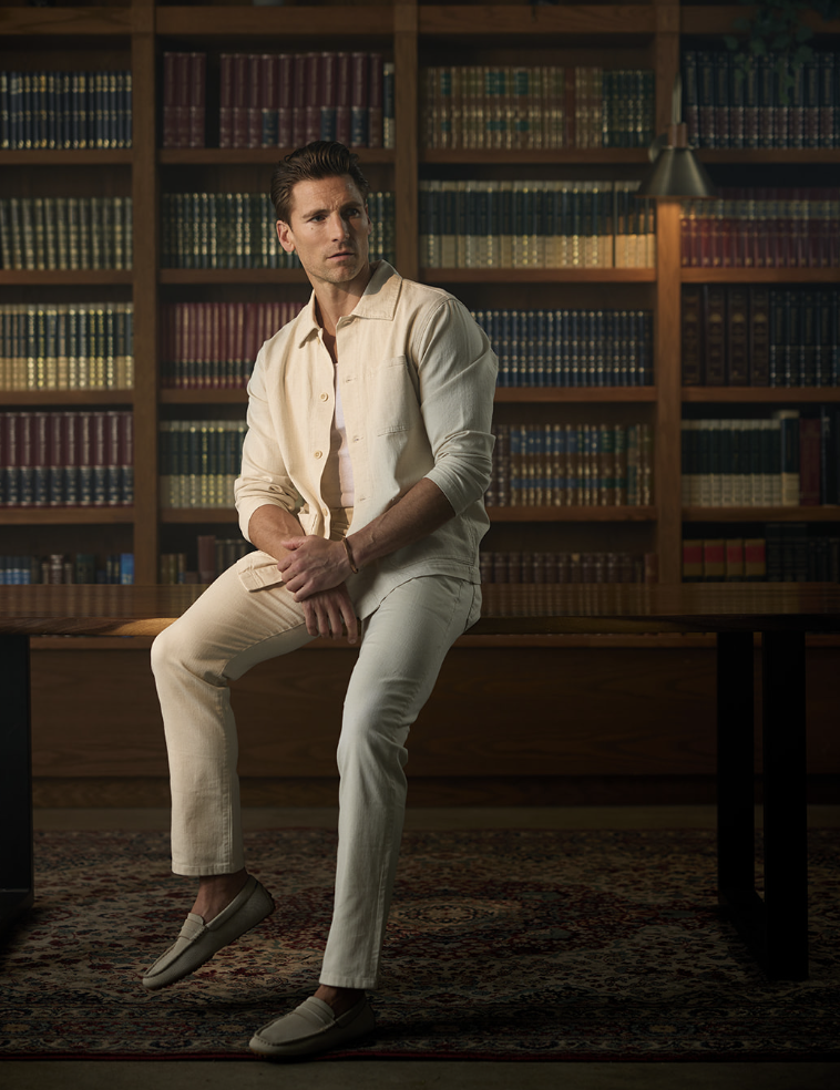 Andrew Walker seated in a warmly lit library